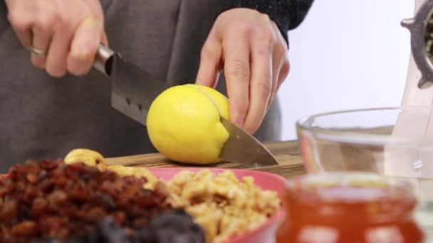 Женщина режет лимон на доске — стоковое видео