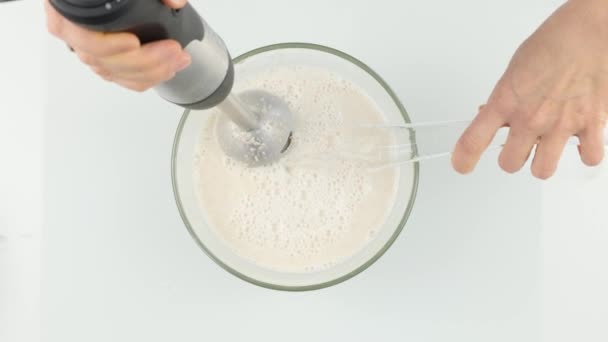 Жінка робить молочний фруктовий коктейль у блендері, готує коктейлі. 4-кілометровий — стокове відео