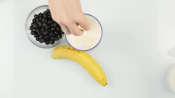 Kvinna blandar en mjölkaktig berry cocktail i en mixer, smoothies förberedelse. 4k — Stockvideo