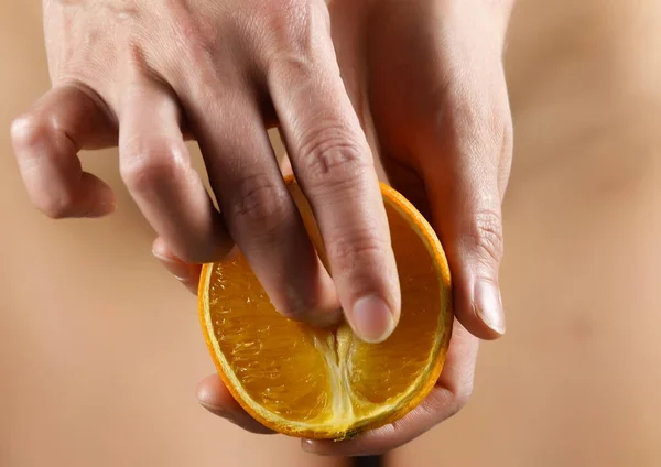 Young woman gently strokes orange slice, juice drips from an orange. concept of satisfaction of womans need — Stock Photo, Image