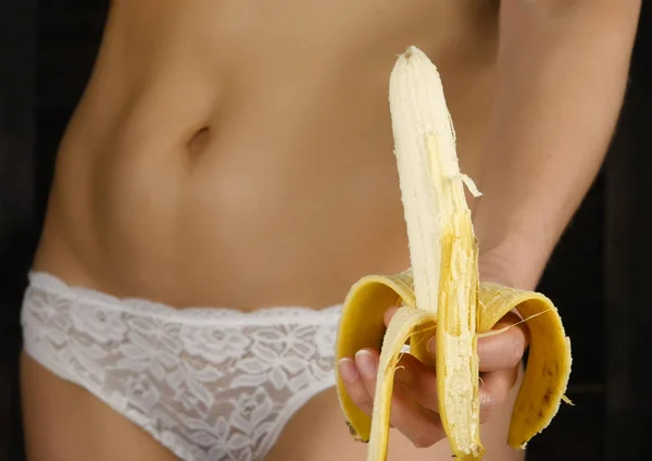 Młoda kobieta bananowy peeling w białe majtki. szczegół pośladki i biodra. — Zdjęcie stockowe