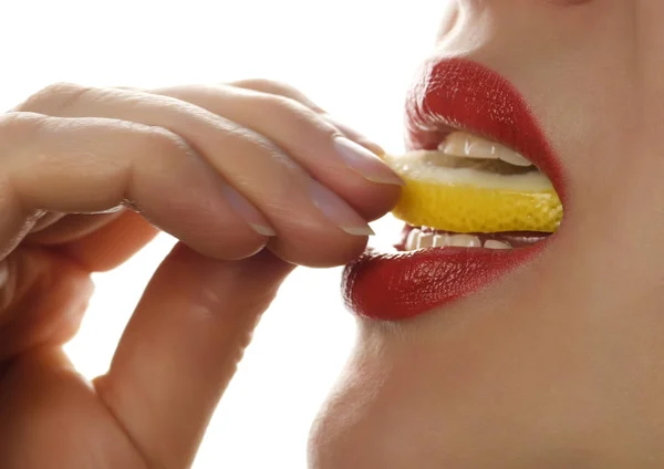 Hermosa mujer lame y comer pedazo de naranja sobre un fondo blanco. Gran comida para un estilo de vida saludable . —  Fotos de Stock