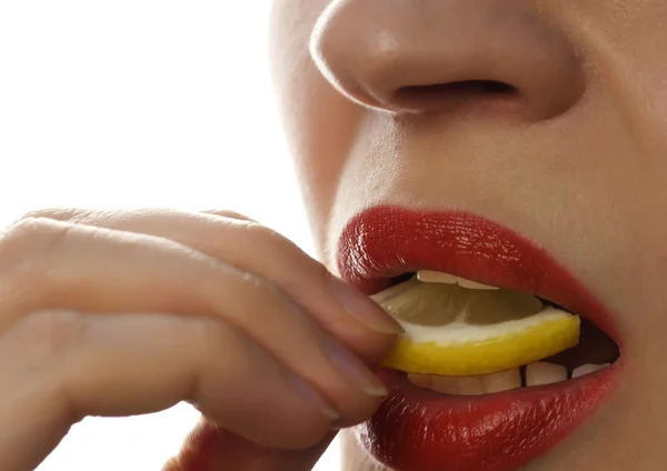 Mulher comendo limão suculento, close-up lábios sexy em um fundo branco . — Fotografia de Stock