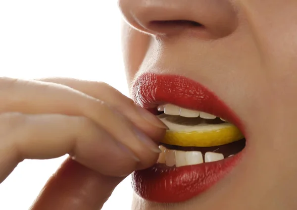 Mujer comiendo jugoso limón, primeros planos sexy labios sobre un fondo blanco . —  Fotos de Stock