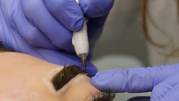 Косметолог делает татуировку бровей клиентке. профессиональные брови постоянный макияж. 4K — стоковое видео
