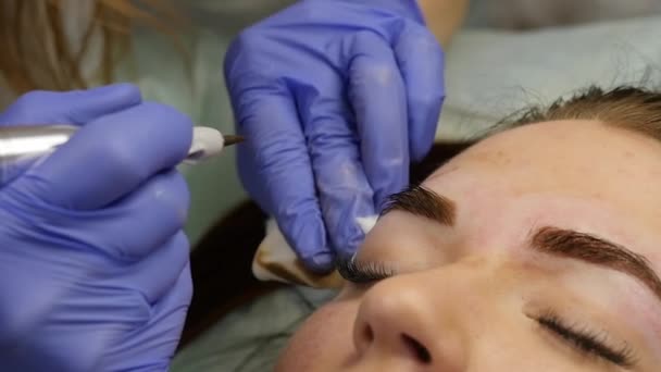 Ung vacker kvinna att få ögonbrynen tatuering. permanent makeup för ögonbrynen på skönhetssalong. slowmotion — Stockvideo