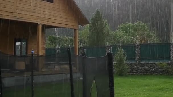 Ducha de lluvia fuerte en el patio trasero en la casa sin terminar. cámara lenta — Vídeo de stock