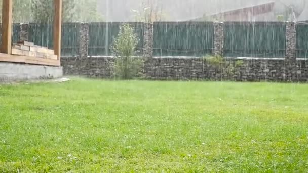Zware regendouche in achtertuin in onvoltooide house. Slow motion — Stockvideo