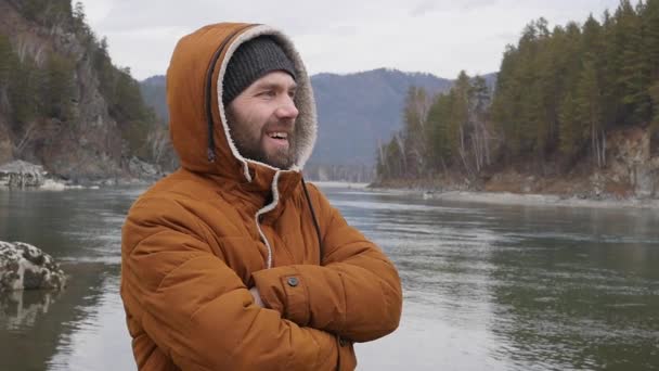 Mladý Pohledný Muž Stojí Břehu Horské Řeky Chladném Počasí — Stock video
