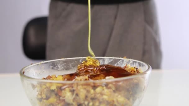 Woman adding honey to a nut butter and mixing ingredients in bowl — Stock Video