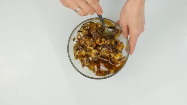 Женщина добавляет мед в ореховое масло и смешивает ингредиенты в миску. 4K — стоковое видео