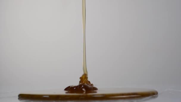 Close-up van honing druipen. Gieten honing op oppervlak. Slow Motion. — Stockvideo