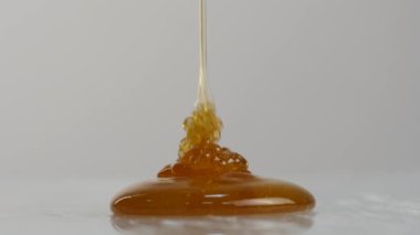 Bal damlayan yakın çekim. Tatlım yüzeyinde dökme. 4k