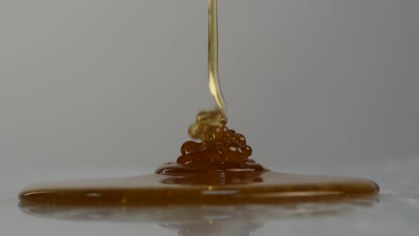 Detail medu kape. Lití med na povrchu. Zpomalený pohyb.