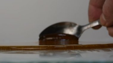 Tatlım kaşıkla dökme. yüzeye damlaması tatlım. Ağır çekim.