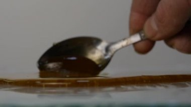 Tatlım kaşıkla dökme. yüzeye damlaması tatlım. Ağır çekim.