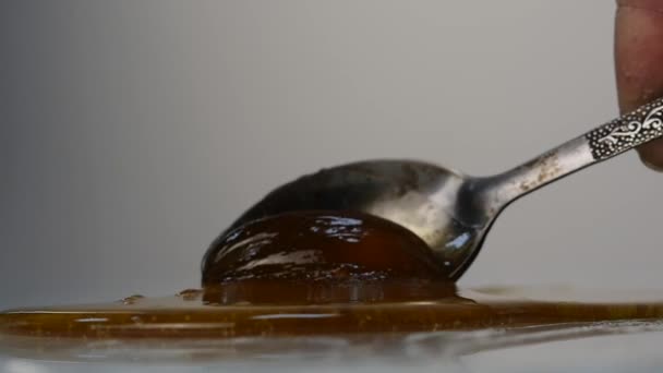 Hälla honung med sked. honung droppade på ytan. Slow Motion. — Stockvideo