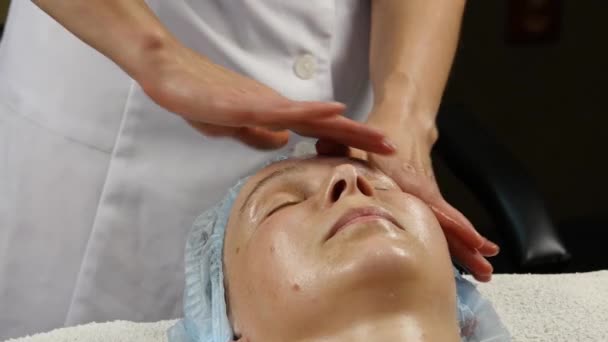 Frau erhält Kopfmassage im Wellnesszentrum. Ärztin bei der Gesichtsmassage. 4k — Stockvideo