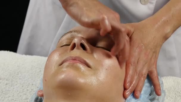 Massagem facial de plástico em saton spa. mulher goza dos serviços de um terapeuta de massagem profissional. 4K — Vídeo de Stock