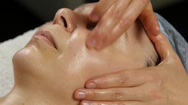 Massagem facial de plástico em saton spa. mulher goza dos serviços de um terapeuta de massagem profissional. 4K — Vídeo de Stock