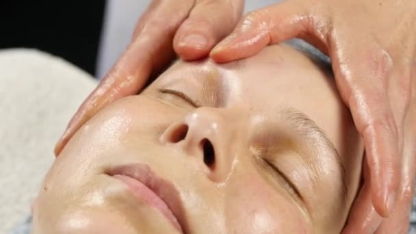 Doctora haciendo masajes antienvejecimiento al cliente. mujer disfruta de masaje facial de plástico en satén spa. 4K — Vídeos de Stock