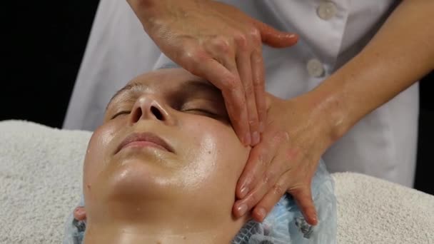 Massagem facial de plástico no salão de spa. mulher goza dos serviços de um terapeuta de massagem profissional. câmara lenta — Vídeo de Stock