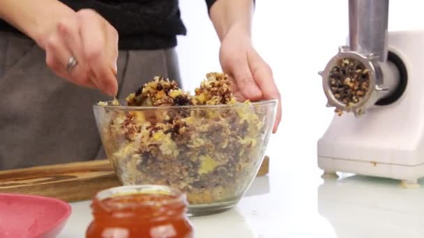 Woman adding honey to a nut butter and mixing ingredients in bowl — Stock Video