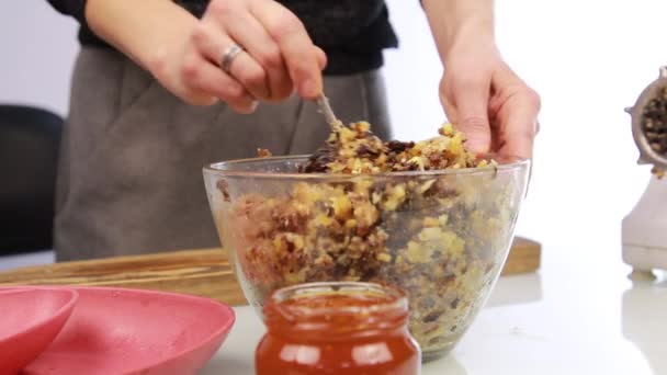 Женщина добавляет мед в ореховое масло и смешивает ингредиенты в миску — стоковое видео