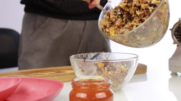 Mujer añadiendo miel a una mantequilla de nuez y mezclando ingredientes en un tazón — Vídeos de Stock