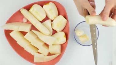 kadının bir bıçak ile bir muz dilimleri eller. Üstten görünüm. 4k