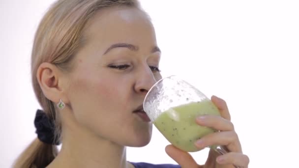 金发碧眼的女孩喝绿色排毒鸡尾酒。蔬菜冰沙健身和健康的生活方式 — 图库视频影像