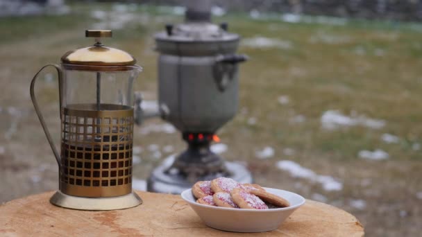 Se vierte el té en una taza en el patio trasero durante la estación fría. Gran samovar viejo. 4K — Vídeos de Stock