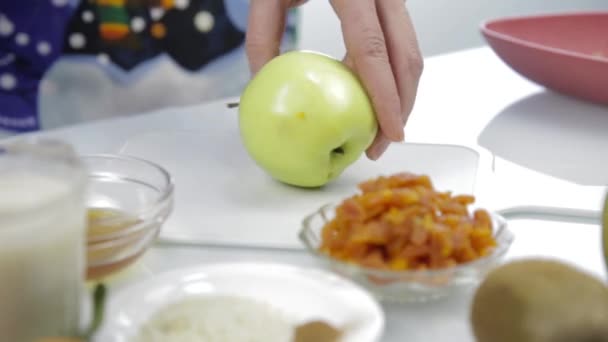 女人的手在厨房的切菜板上切了一个苹果。烹饪健康食品 — 图库视频影像