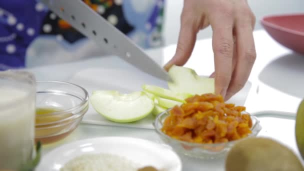 Las mujeres cortan las manos de manzana en la tabla de cortar en una cocina. cocinar alimentos saludables — Vídeos de Stock