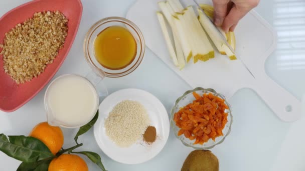 Bovenaanzicht van dames handen snijden peer op hakken bestuur in een keuken. Koken gezond voedsel. 4k — Stockvideo