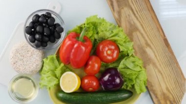 Üstten görünüm. Kadının Dilimleme tatlı kırmızı dolmalık biber mutfak masası üzerinde eller. Ahşap kesme tahtası üzerinde kesme sebze. 4k