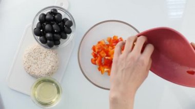 Üstten görünüm. kadın pişirme vejetaryen düşük kalorili salata, bir kase sebze koyar. 4k