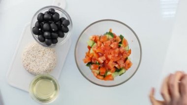Üstten görünüm. kadın pişirme vejetaryen düşük kalorili salata, bir kase sebze koyar. 4k