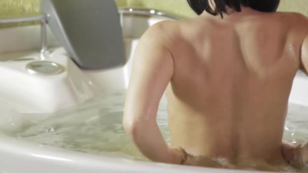 Hermosa mujer tomando un baño de burbujas. Vista trasera, espalda femenina desnuda — Vídeo de stock