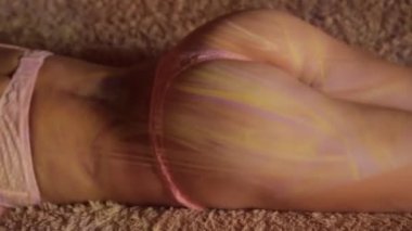 Güzel seksi eşek bir yatakta çizgili gölgeli Pembe külot. Çekici kadın bedeninin bir otel odasında dinleniyor.