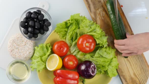 Üstten görünüm. Mutfak masasının üstünde salatalık salatası için dilimleme kadın. Ahşap kesme tahtası üzerinde kesme sebze. 4k — Stok video