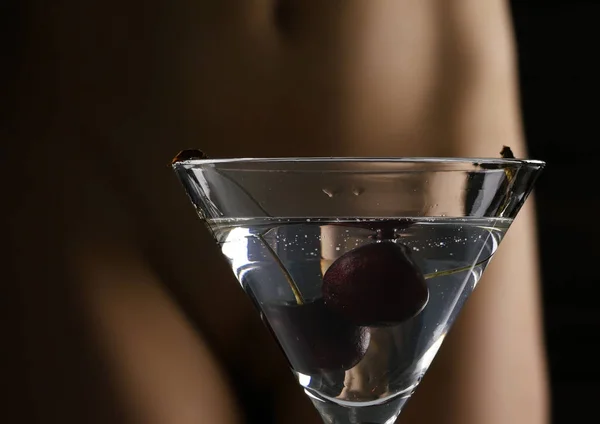 鸡尾酒与樱桃和花黑的女性臀部在白色内裤在黑暗的背景。约会和派对概念. — 图库照片