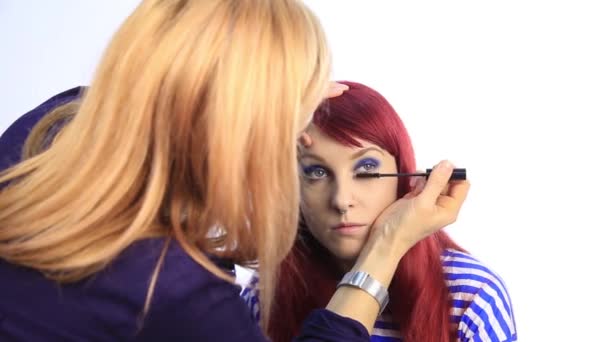 Maquillador profesional tiñe los ojos de la modelo. estilista pinta pestañas — Vídeo de stock
