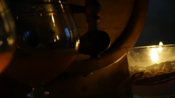 Коньячный бокал при свечах с деревянными бочками в романтический вечер. замедленное движение — стоковое видео