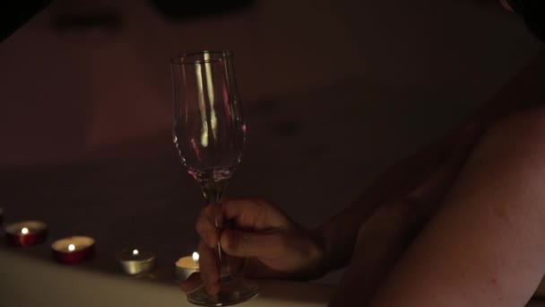 Vista trasera de una mujer joven y bonita relajándose en un baño y bebiendo champán — Vídeo de stock