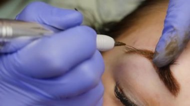 Genç güzel kadın Başlarken kaşları dövme. kalıcı makyaj Güzellik Salonu kaşları için. ağır çekim