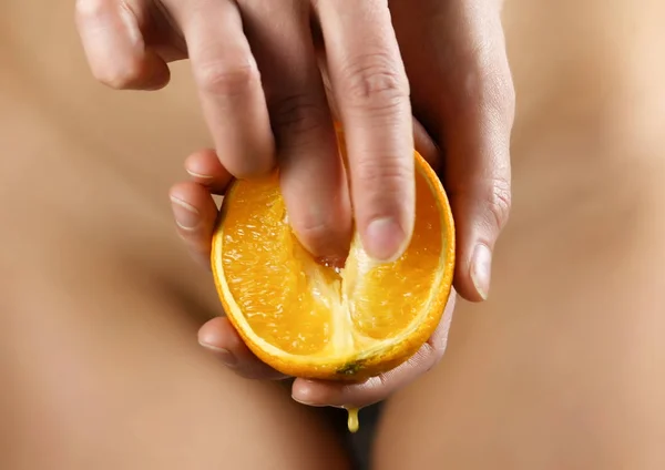 Jonge vrouw lijnen zacht oranje segment, druppels van het SAP van een sinaasappel. concept van tevredenheid van dames behoefte — Stockfoto