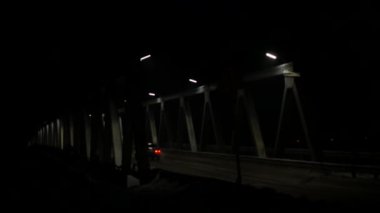 akşam araba trafiği olan eski demir köprü. arabalar geçerken ışık farlar. 4k