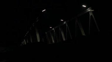 akşam araba trafiği olan eski demir köprü. arabalar geçerken ışık farlar. 4k
