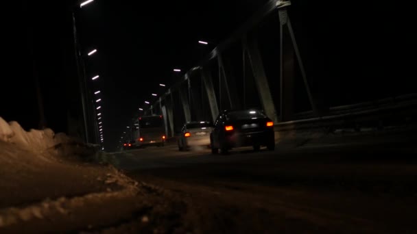 Alte Eisenbrücke mit Autoverkehr am Abend. Scheinwerfer von vorbeifahrenden Autos. 4k — Stockvideo